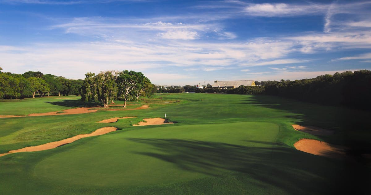 Aerial view of a golf course fairway with sand bunkers and dramatic sky